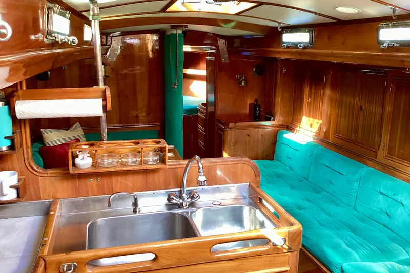 Slide: The Image of Interior of 1980 F&C 44 yacht with wooden finish and turquoise seating. - 3