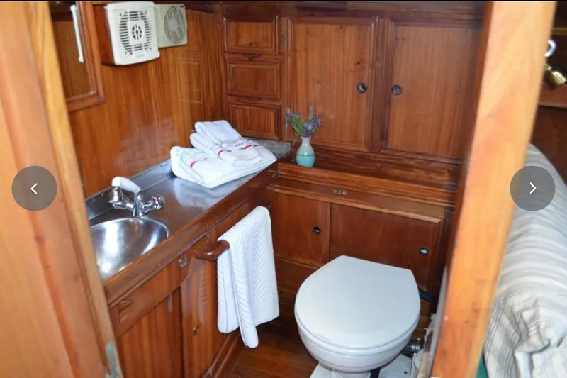 Slide: The Image of Wooden boat bathroom with sink, toilet, and towels; F&C 44, 1980 model. - 32
