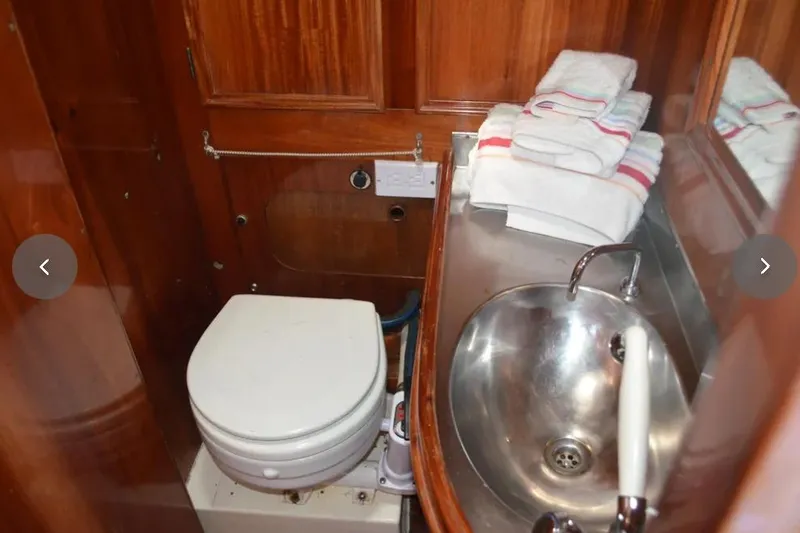 Slide: The Image of Compact wooden boat bathroom with sink, toilet, and neatly stacked towels, F&C 44, 1980. - 34