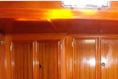 Slide: The Image of Wooden interior of 1980 F&C 44 yacht, featuring polished cabinets and warm lighting. - 35