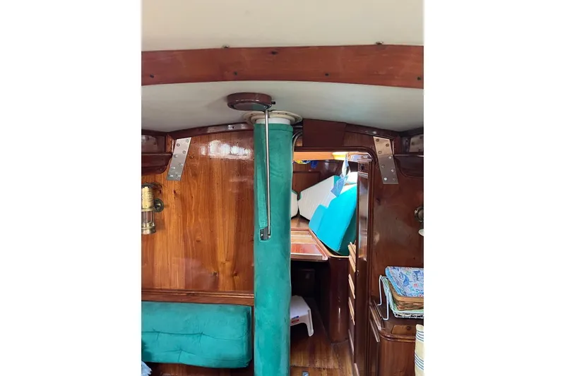 Slide: The Image of Interior of 1980 F&C 44 sailboat with wooden paneling and teal upholstery. - 36