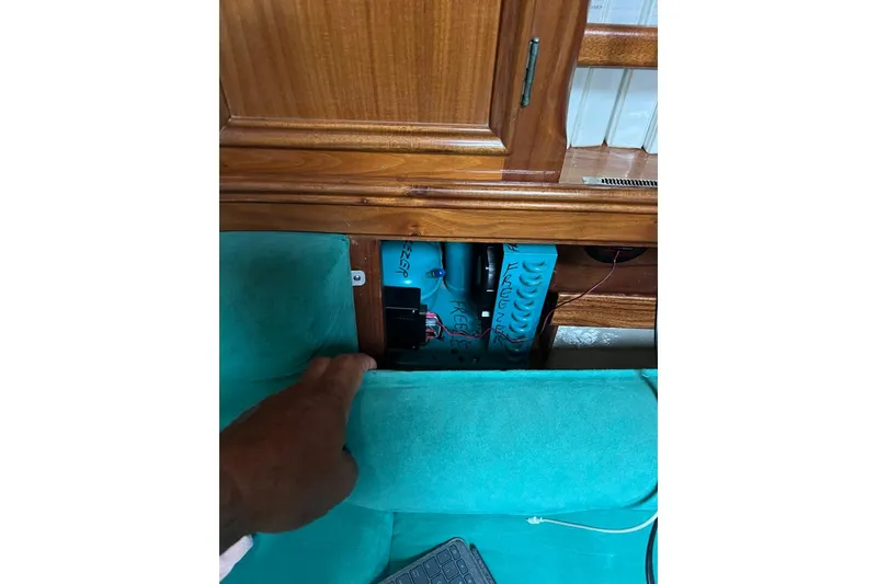 Slide: The Image of Interior view of a 1980 F&C 44 yacht, showcasing wooden cabinetry and teal upholstery. - 40