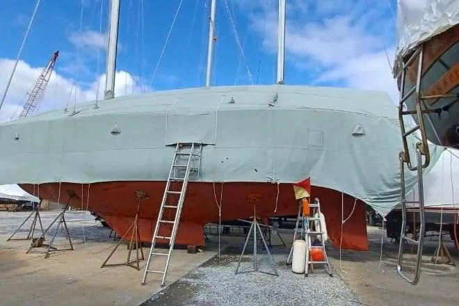 Slide: The Image of 1980 F&C 44 sailboat on dry dock with ladders and supports. - 49