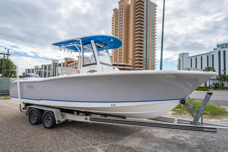 The Image of 2018 Sea Hunt Ultra 255 SE boat on trailer, urban background, cloudy sky. - 0