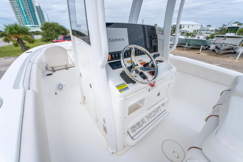Slide: The Image of 2018 Sea Hunt Ultra 255 SE boat interior with white seating and Garmin navigation system. - 15