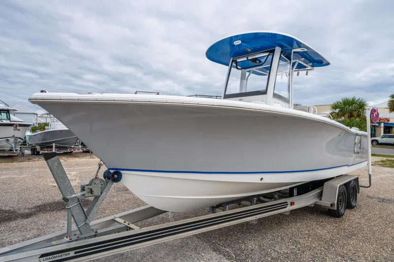 Slide: The Image of 2018 Sea Hunt Ultra 255 SE boat on trailer, parked outdoors under cloudy sky. - 2