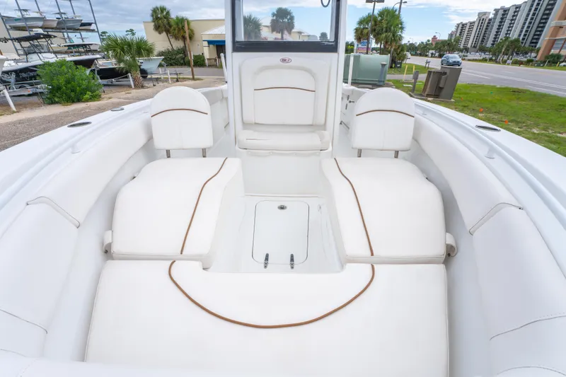 Slide: The Image of 2018 Sea Hunt Ultra 255 SE boat with blue canopy, docked in a marina. - 25