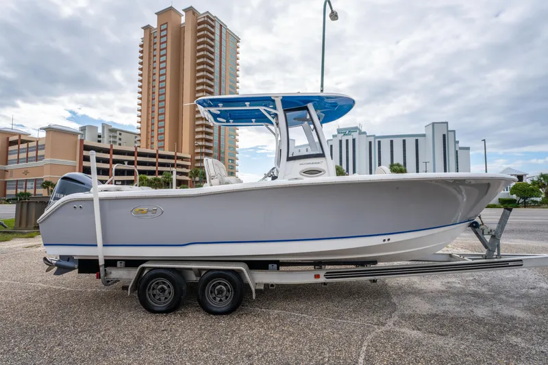 Slide: The Image of 2018 Sea Hunt Ultra 255 SE boat on trailer, urban background, cloudy sky. - 5