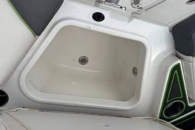 Slide: The Image of 2022 Tahoe 210 S boat interior with built-in storage compartment. - 21