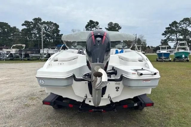 Slide: The Image of 2022 Tahoe 210 S boat with outboard motor, parked on grass near other boats. - 7