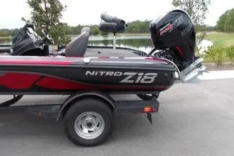 Slide: The Image of 2023 Nitro Z18 boat with powerful outboard motor on a trailer by a lake. - 5