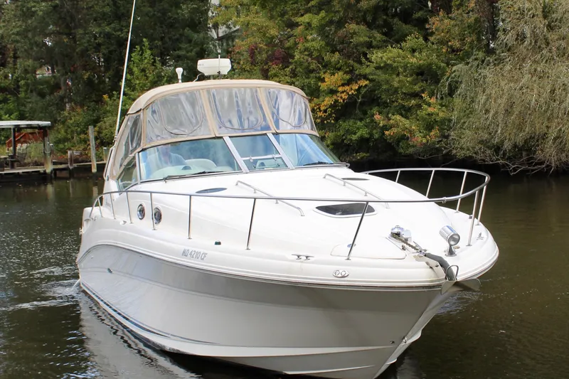 Slide: The Image of 2004 Sea Ray 340 Sundancer yacht cruising on a serene river. - 10