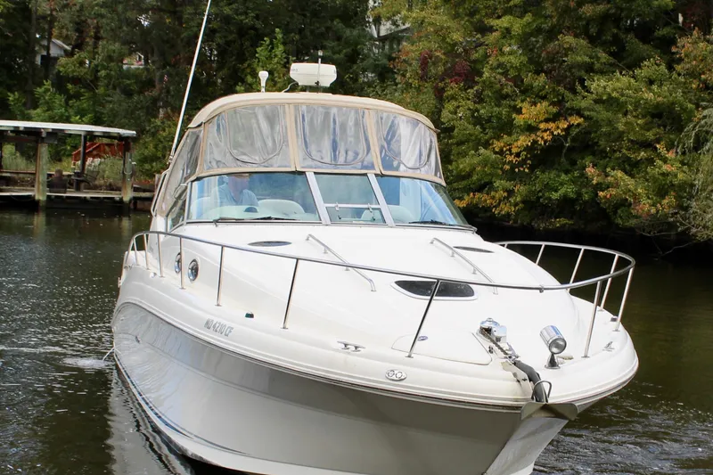 Slide: The Image of 2004 Sea Ray 340 Sundancer cruising on a serene river with lush greenery. - 11