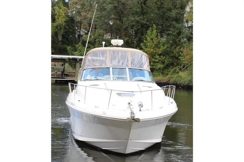 Slide: The Image of 2004 Sea Ray 340 Sundancer yacht on a calm river, surrounded by lush greenery. - 12