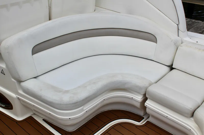 Slide: The Image of White leather seating on 2004 Sea Ray 340 Sundancer boat, featuring curved design and wooden flooring. - 15