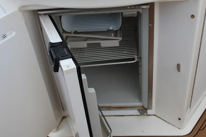 Slide: The Image of Open refrigerator on 2004 Sea Ray 340 Sundancer boat, showing interior shelves. - 18