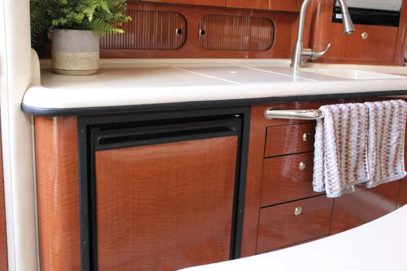 Slide: The Image of 2004 Sea Ray 340 Sundancer kitchen with wood cabinetry, sink, and towel. - 29