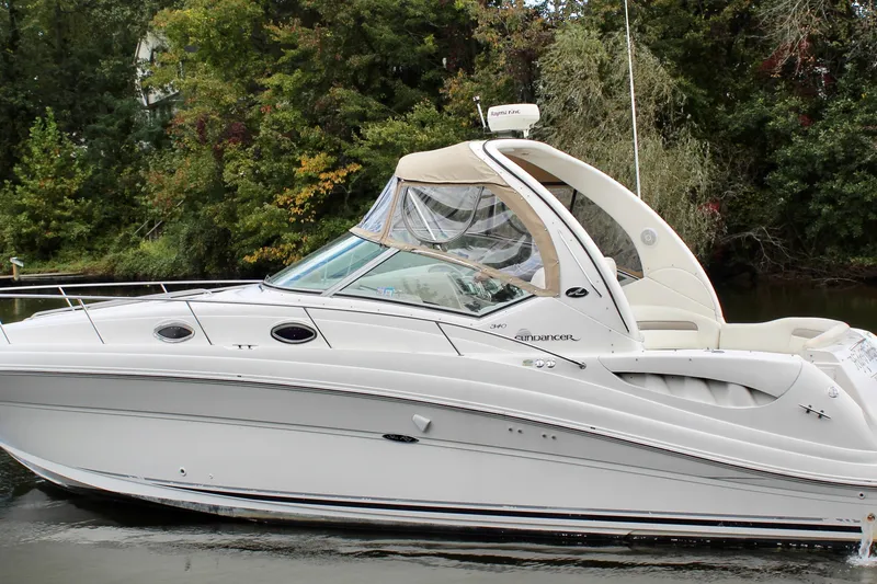 Slide: The Image of 2004 Sea Ray 340 Sundancer yacht on calm water, surrounded by lush greenery. - 3