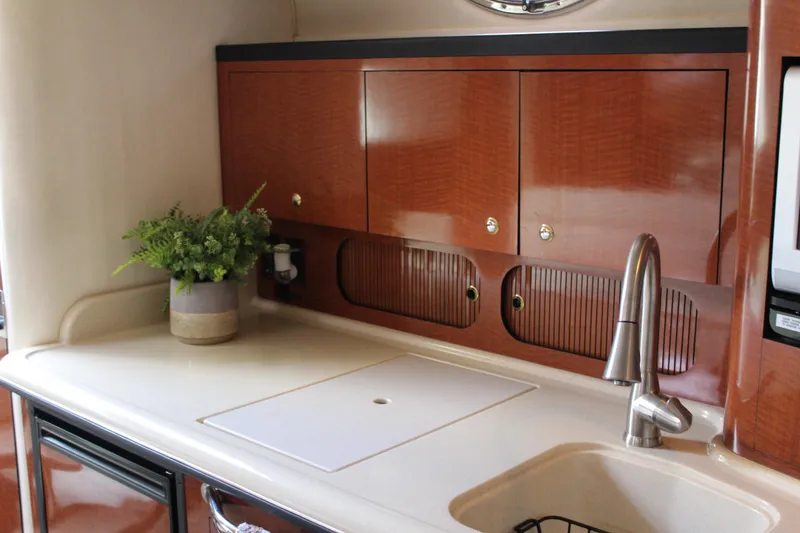 Slide: The Image of 2004 Sea Ray 340 Sundancer kitchen with wooden cabinets and modern sink. - 30