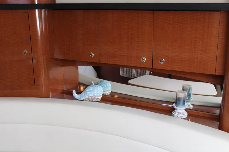 Slide: The Image of Interior of 2004 Sea Ray 340 Sundancer with wooden cabinets and decorative items. - 31