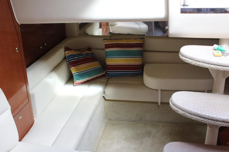 Slide: The Image of 2004 Sea Ray 340 Sundancer cabin interior with striped cushions and cozy seating area. - 32
