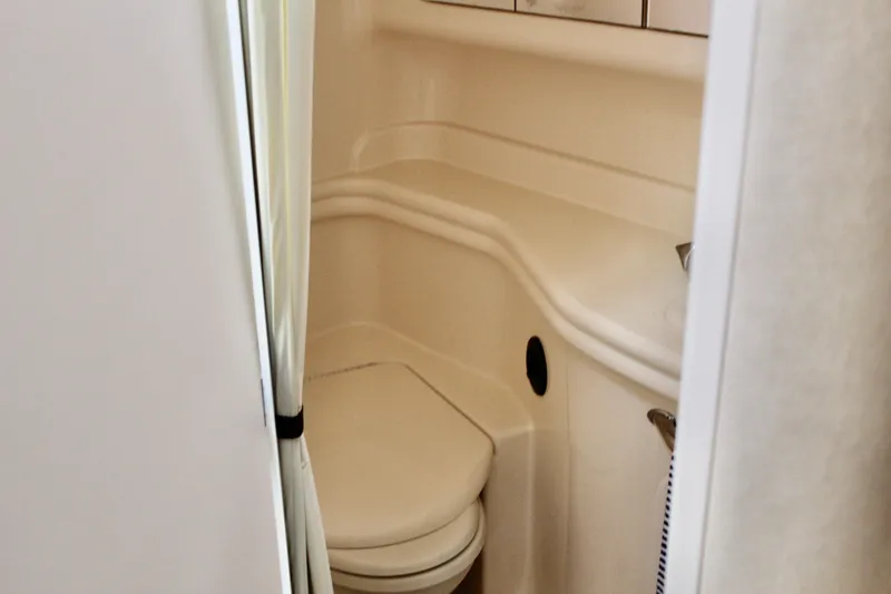 Slide: The Image of 2004 Sea Ray 340 Sundancer bathroom interior with compact design and white fixtures. - 33