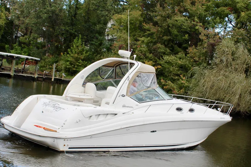 Slide: The Image of 2004 Sea Ray 340 Sundancer cruising on a calm river, surrounded by lush greenery. - 7