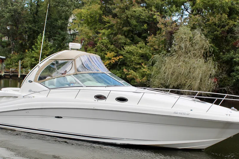 Slide: The Image of 2004 Sea Ray 340 Sundancer yacht cruising on a serene waterway, surrounded by lush greenery. - 8