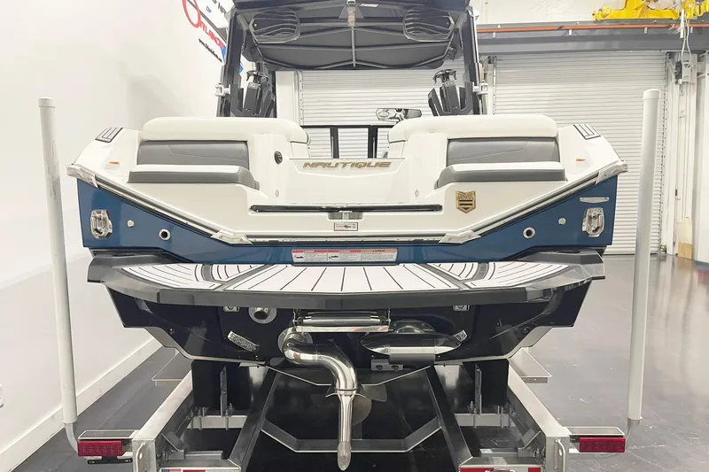 Slide: The Image of 2023 Nautique Super Air Nautique G23 boat on trailer, rear view in showroom. - 4