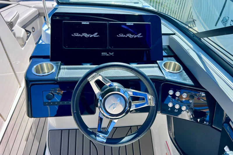 Slide: The Image of 2024 Sea Ray SLX 260 Outboard dashboard with steering wheel and control panel. - 10