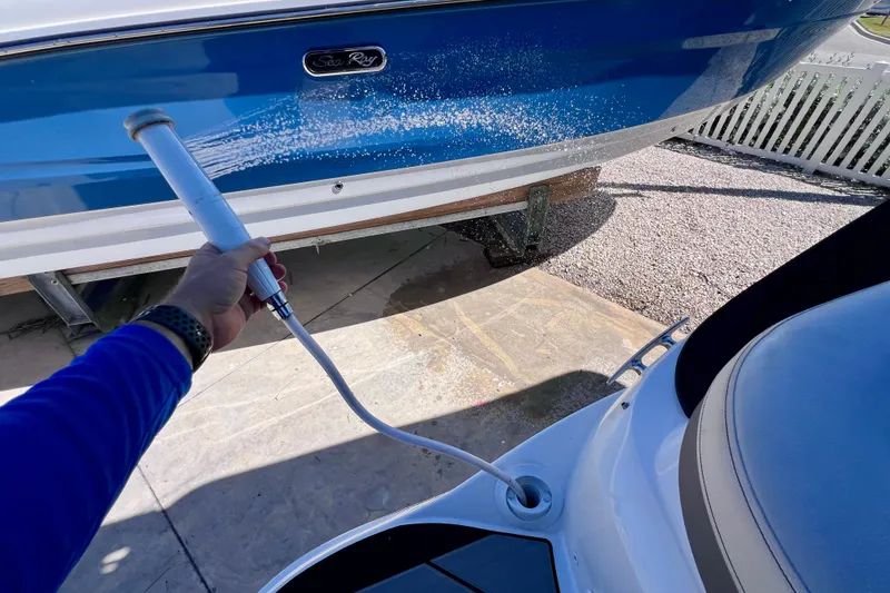 Slide: The Image of Washing a 2024 Sea Ray SLX 260 Outboard boat with a hose. - 14
