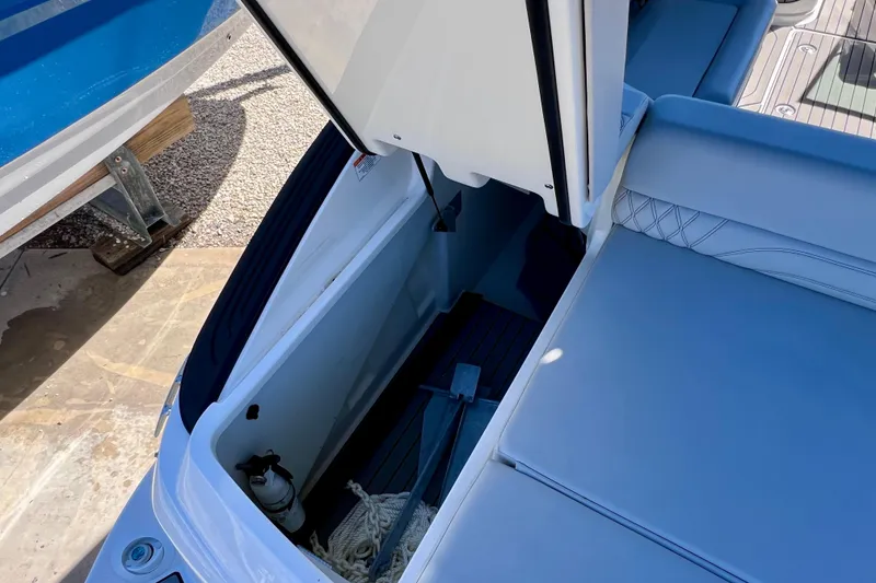 Slide: The Image of 2024 Sea Ray SLX 260 Outboard storage compartment with open hatch and visible equipment. - 15