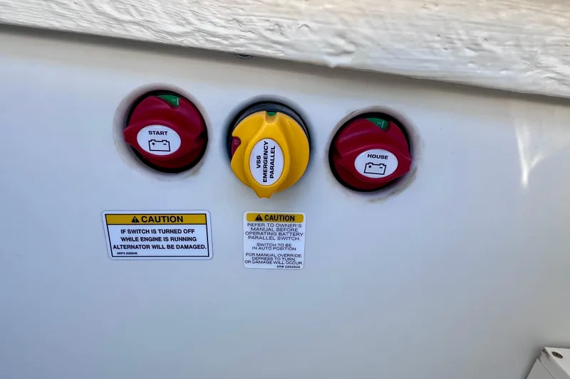 Slide: The Image of Battery switches on 2024 Sea Ray SLX 260 Outboard with caution labels. - 18