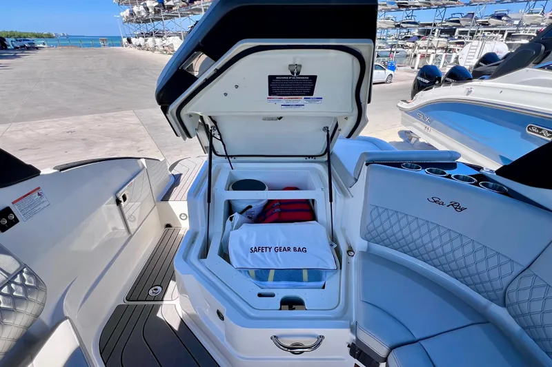 Slide: The Image of 2024 Sea Ray SLX 260 Outboard boat with open storage compartment and safety gear bag. - 27