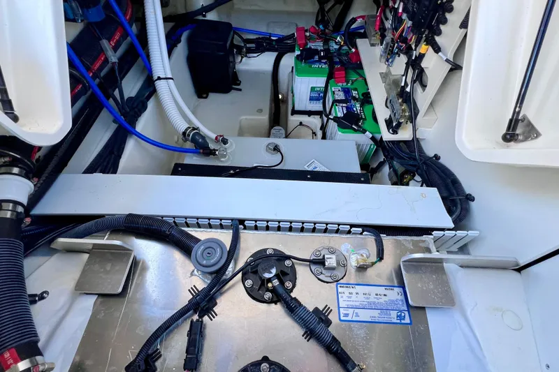Slide: The Image of 2024 Sea Ray SLX 260 Outboard engine compartment with wiring and battery setup. - 29