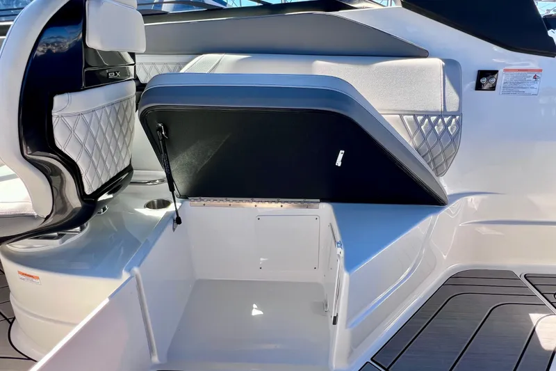 Slide: The Image of 2024 Sea Ray SLX 260 Outboard interior with open storage compartment and luxurious seating. - 32