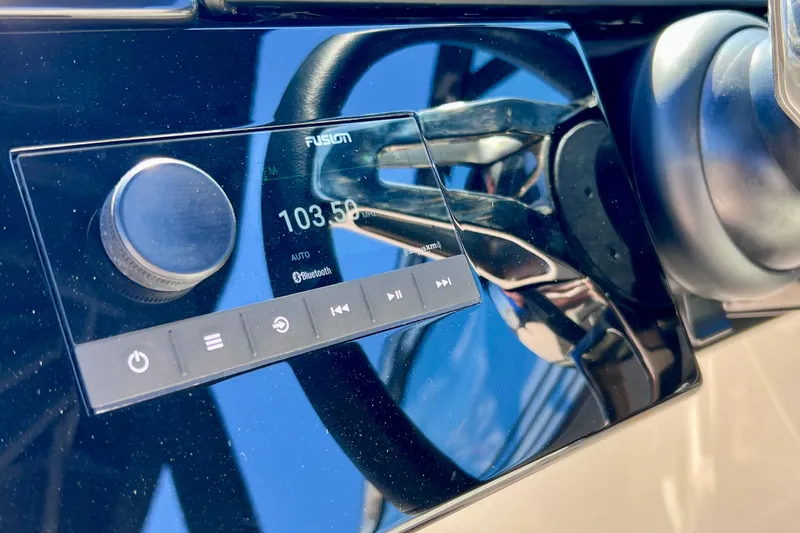 Slide: The Image of 2024 Sea Ray SLX 260 Outboard dashboard with Fusion audio system and steering wheel. - 47