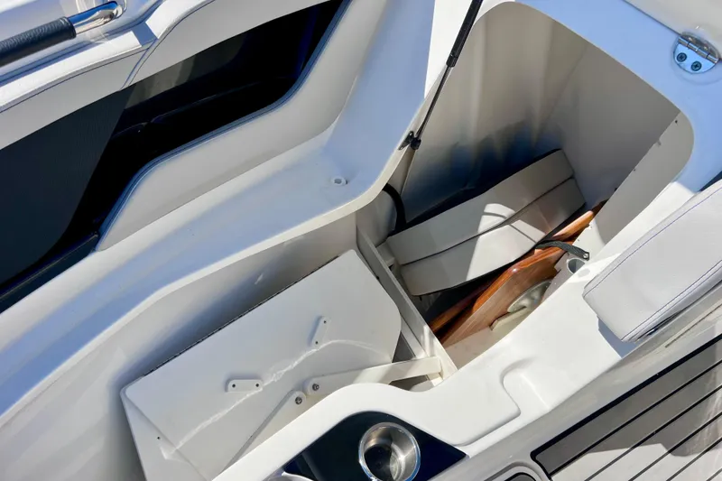 Slide: The Image of 2024 Sea Ray SLX 260 Outboard storage compartment with seating and cup holder. - 59