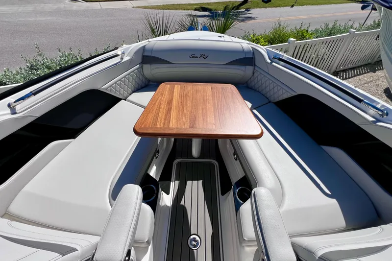 Slide: The Image of 2024 Sea Ray SLX 260 Outboard interior with elegant seating and wooden table. - 64