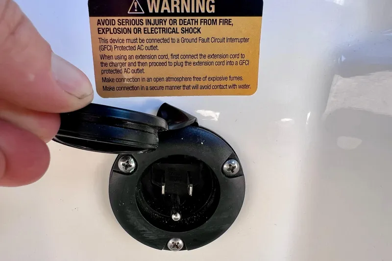 Slide: The Image of 2024 Sea Ray SLX 260 Outboard power outlet with safety warning label. - 67