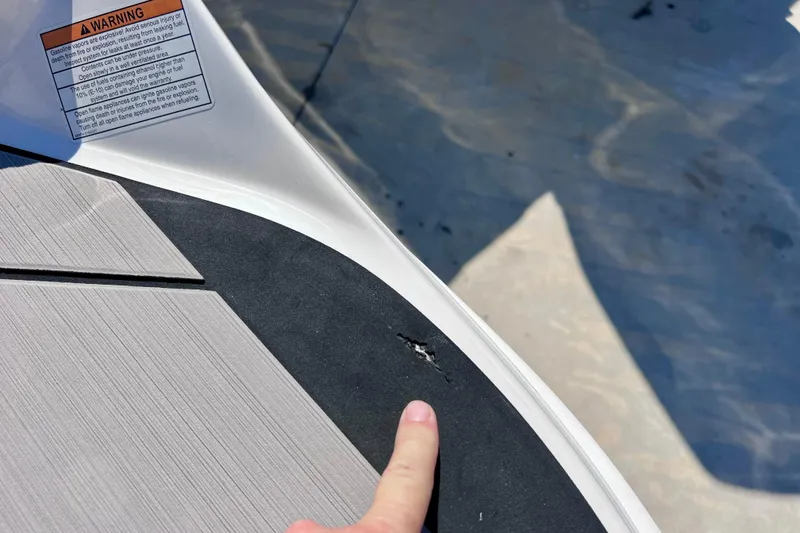 Slide: The Image of 2024 Sea Ray SLX 260 Outboard with minor deck damage and warning label. - 70