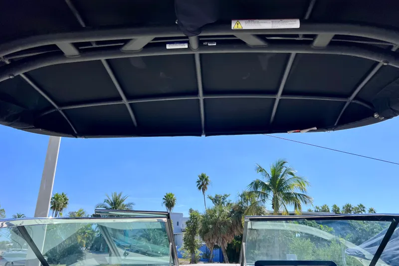 Slide: The Image of 2024 Sea Ray SLX 260 Outboard boat with canopy, palm trees in background. - 72