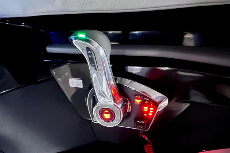 Slide: The Image of 2024 Sea Ray SLX 260 Outboard throttle control with illuminated buttons and sleek design. - 78