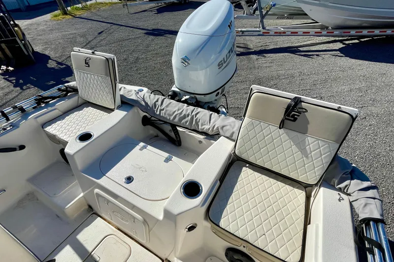 Slide: The Image of 2021 Carolina Skiff 17 LS boat interior with cushioned seating and Suzuki outboard motor. - 15