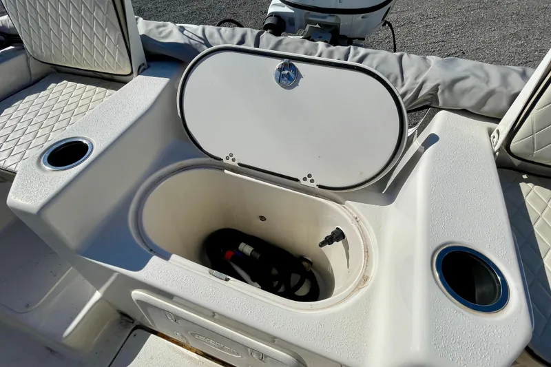 Slide: The Image of 2021 Carolina Skiff 17 LS boat storage compartment with open lid and cup holders. - 17