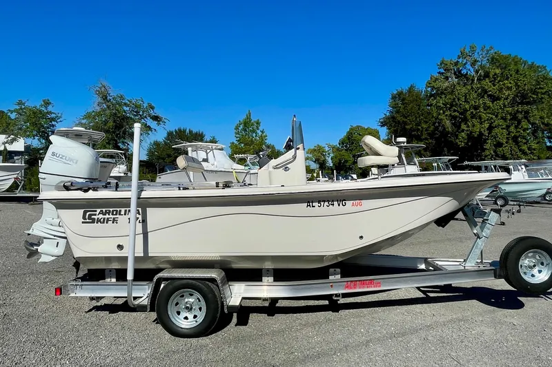 Slide: The Image of 2021 Carolina Skiff 17 LS boat on trailer, featuring Suzuki outboard motor. - 2