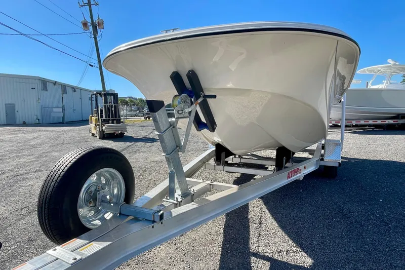 Slide: The Image of 2021 Carolina Skiff 17 LS boat on trailer, parked outdoors under clear blue sky. - 7
