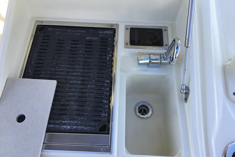 Slide: The Image of 2016 Chris-Craft Calypso 26 boat sink and grill area with chrome faucet. - 12
