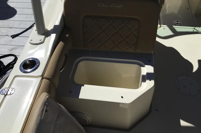 Slide: The Image of 2016 Chris-Craft Calypso 26 boat interior with open storage compartment and cushioned seating. - 14
