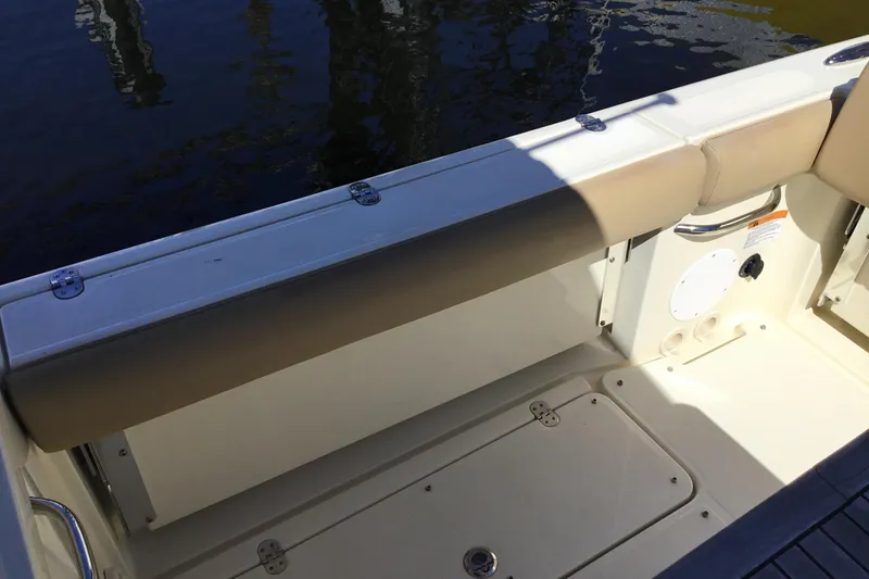 Slide: The Image of 2016 Chris-Craft Calypso 26 boat interior with beige seating and storage compartment. - 16